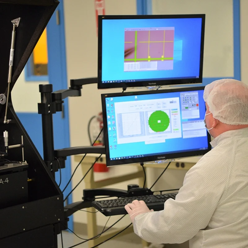 man wearing a mask and hairnet using lab machinery