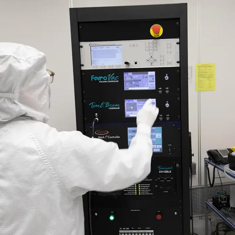 person in a clean suit in a lab using machinery